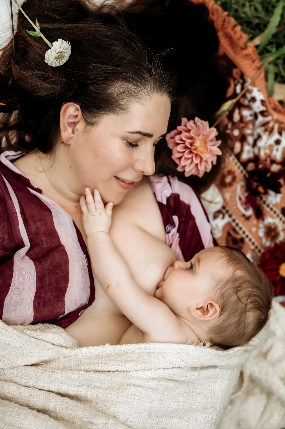 A mother lying down and breastfeeding her baby.
